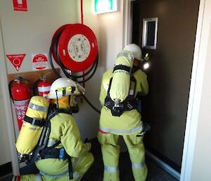 Two blind folded expeditioners searching a building for a fire drill