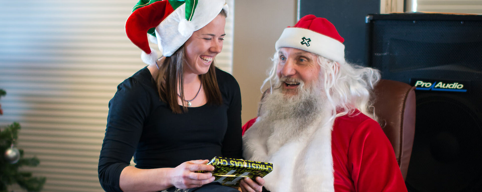 An expeditioner on Santa’s knee getting a present