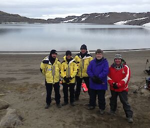 Five expeditioners on field training near a lake