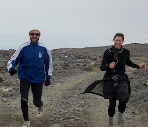 A male and female expeditioner running along a track at Davis