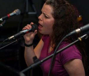 An expeditioner singing in front of the band.