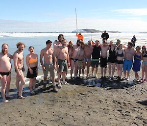 About twenty expeditioners in their bathers posing for a photo prior to the swim