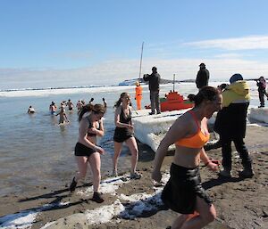 Three expeditioners running out of the water