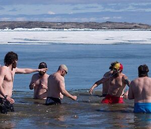 A group of expeditioners in the cold sea water of Davis