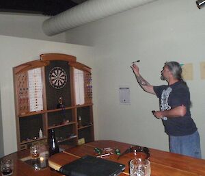 An expeditioner throwing a dart at a dart board