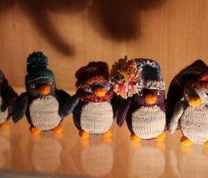 Five knitted penguins in various shapes and sizes