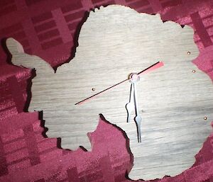 A wooden clock in the shap of Antarctica