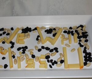 Cheese platter with the cheese spelling out "We will miss you"