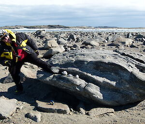 An expeditioner with her foot stuck in a crack in a rock