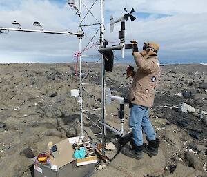 An expeditioner fixing a automatic weather station