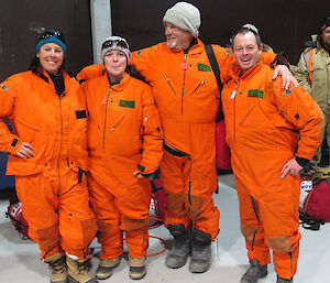 4 expeditioners dressed in orange mustang suits