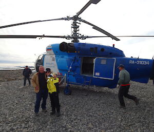 male and female expeditioner with a russian helicopter in the background