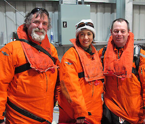 three expeditioners dressed in orange mustang suits