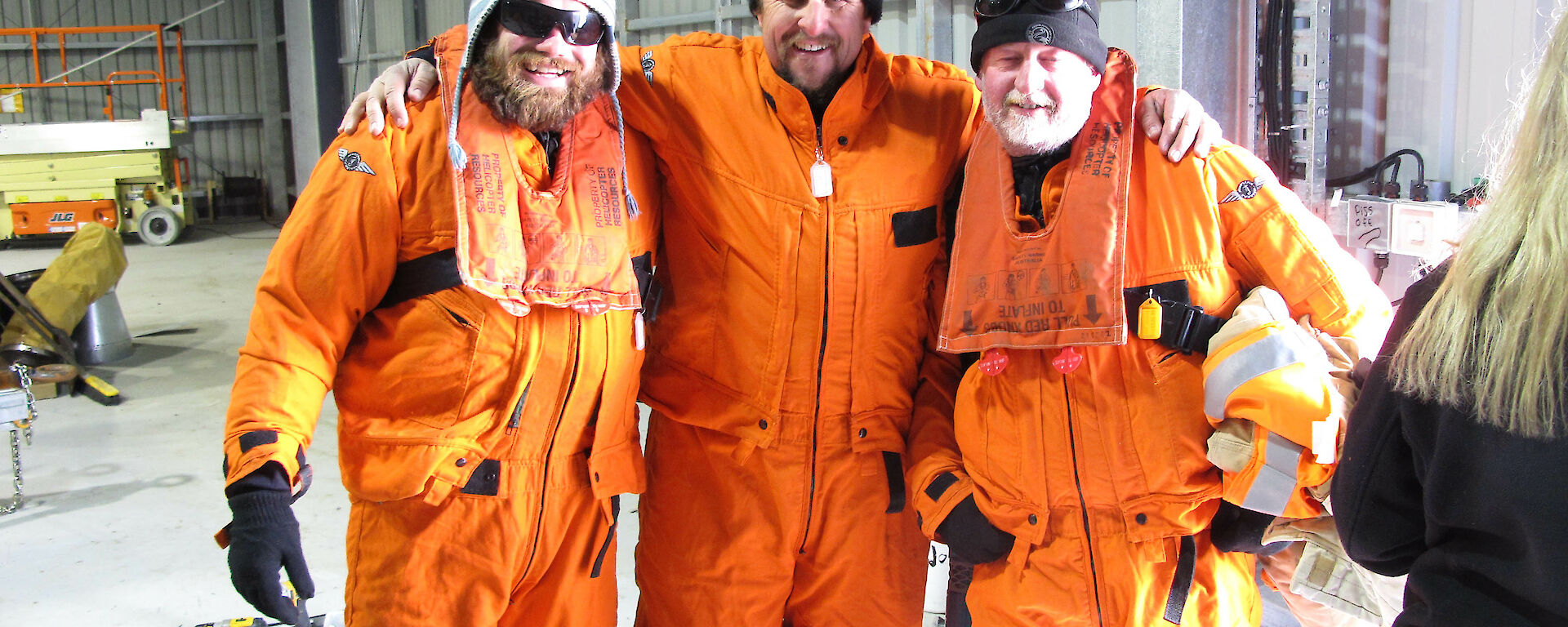 3 bed dressed in orange mustang suits standing together