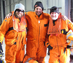 3 bed dressed in orange mustang suits standing together