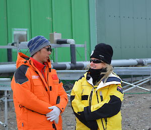 Chinese gentleman chatting with female outside whilst touring station