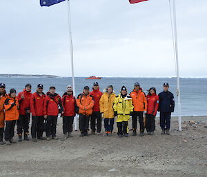 a line up of expeditioners with the Aurora Australis in the background