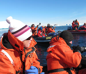 expeditioners in inflatable boats ice bergs in background