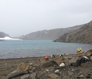 expeditioners at melted lake sampling water