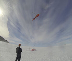 helicopter hovering over fuel drums