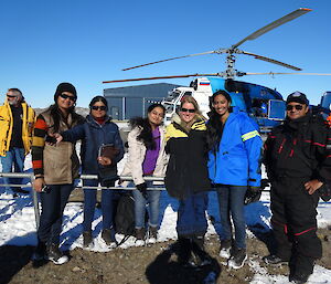 group photo in front of helicopter