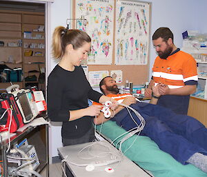 Expeditioner holds the hand of the volunteer patient