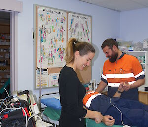 two expeditioners preparing a volunteer patient in the medical facilities