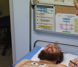 close up photo of Josh on the examiniation bed with Layla looking on