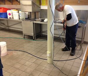 Tradesman cleaning the kitchen floors with a steam cleaner a