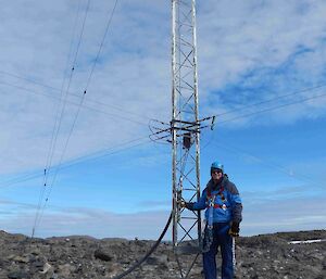 Expeditioner with safety gear on standing alongside loarge antenna