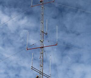 Expeditioner with safety gear on climbing an antenna