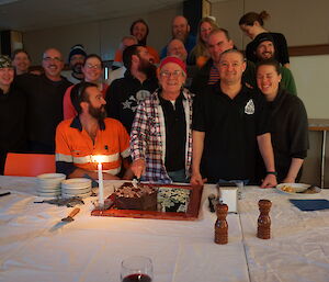 Group of people gathered around expeditioner and his cake