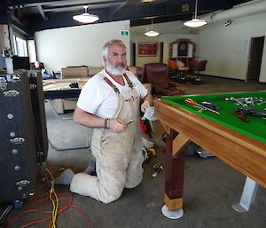 expeditioner with tools repairing pool table