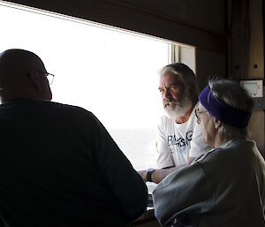 three expeditioners standing by the window admiring the view