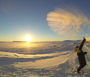 Expeditioner throwing boiling water into the air as it turns into steam