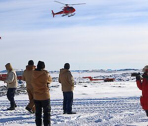 Expeditioners watch two helicopters approach station