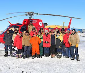 Group photo of winter team with the red helicopter