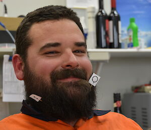 Close up photo of expeditioner with met symbol flags stuck in his beard