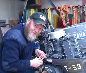 Expeditioner servicing a small outboard motor