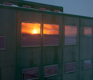 Bright red yellow sunset reflection on building windows