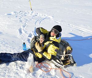 Expeditioner sitting on the sea ice preparing to eat lunch