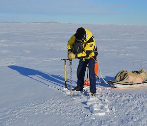 Expeditioner with electric drill making hole in sea ice