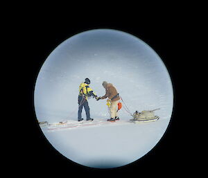 Distant photo of two expeditioners on the sea ice