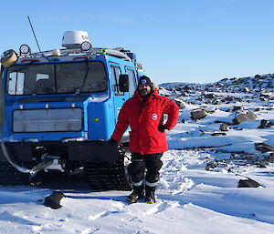 Expeditioner standing next to a blue hagg in the field