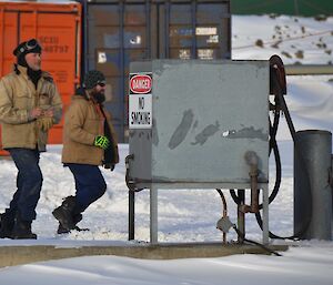 Two expeditioners searching around a hose reel