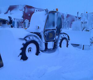 Two heavy vehicles covered in snow