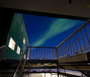 Green aurora between buildings