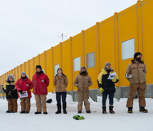 Expeditioners lined up outside the Operations building listening to the service