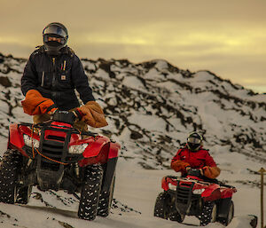 Expeditioner on quad bike leaning uphill