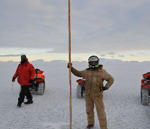 Expeditioner positioning a cane in the sea ice